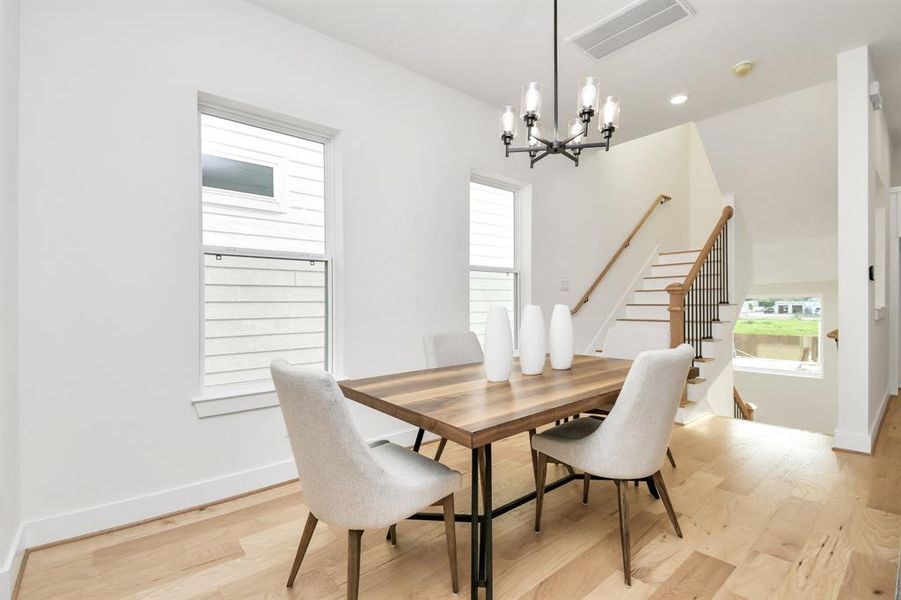 As you move further into the space, you will notice the open and spacious dining area. The large windows in the dining area offer an abundance of natural light, creating a warm and inviting atmosphere as it reveals a hidden feature of the home.