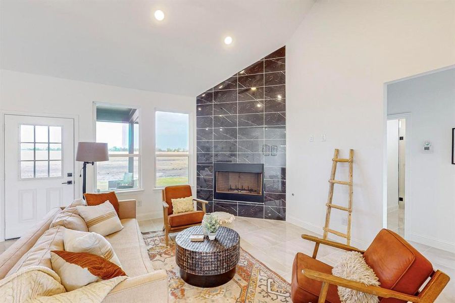 Living room featuring high vaulted ceiling, tile patterned flooring, and a fireplace