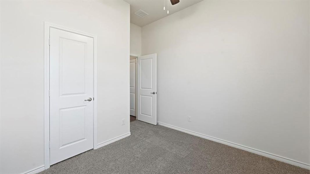 Unfurnished bedroom featuring carpet and ceiling fan Unfurnished bedroom featuring carpet and ceiling fan