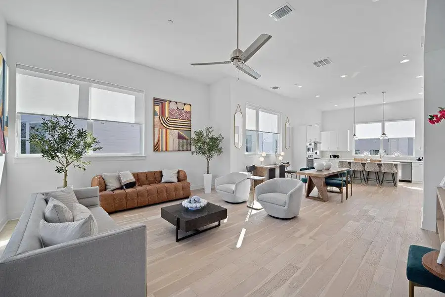 Living room with a ceiling fan and light wood-type flooring Living room with a ceiling fan and light wood-type flooring