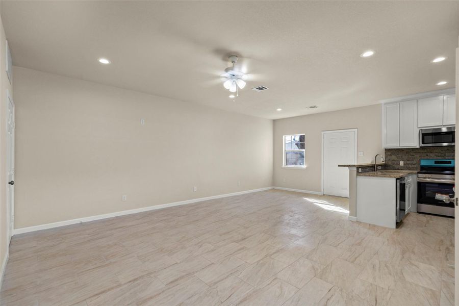 This aerial photo showcases a residential neighborhood with tree-lined streets and a mix of houses. The highlighted property is centrally located, offering easy access to nearby amenities and a view of the city skyline in the distance. Ideal for buyers seeking a well-connected and vibrant community.