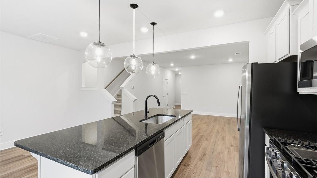 Superior kitchen with granite countertops, pendant lighting, and a generously sized island at the Aspen Ridge community