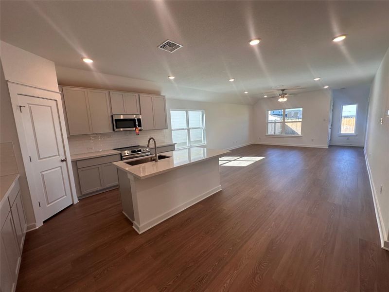 Kitchen with recessed lighting, plenty of natural light, a center island with sink, decorative backsplash, and appliances with stainless steel finishes Kitchen with recessed lighting, plenty of natural light, a center island with sink, decorative backsplash, and appliances with stainless steel finishes