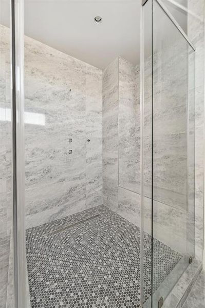 Step into the enormous glass-enclosed, walk-in primary shower.