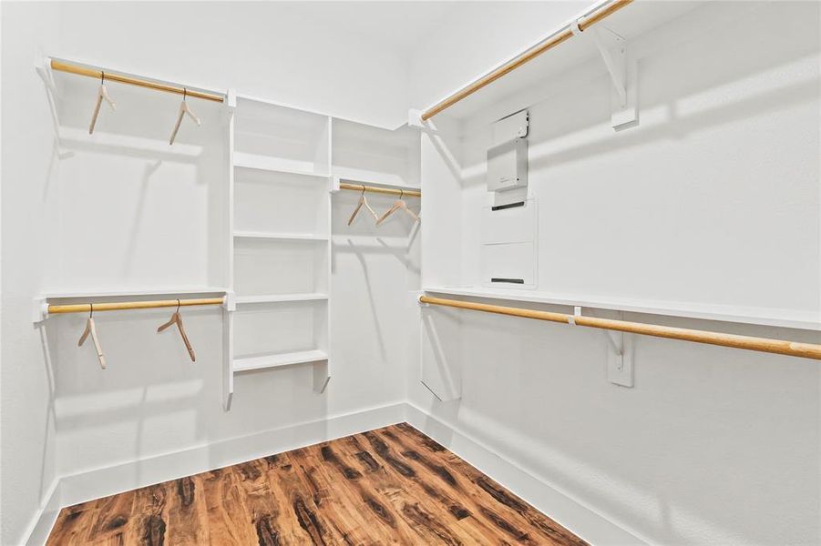 Walk in closet featuring dark wood-style flooring Walk in closet featuring dark wood-style flooring
