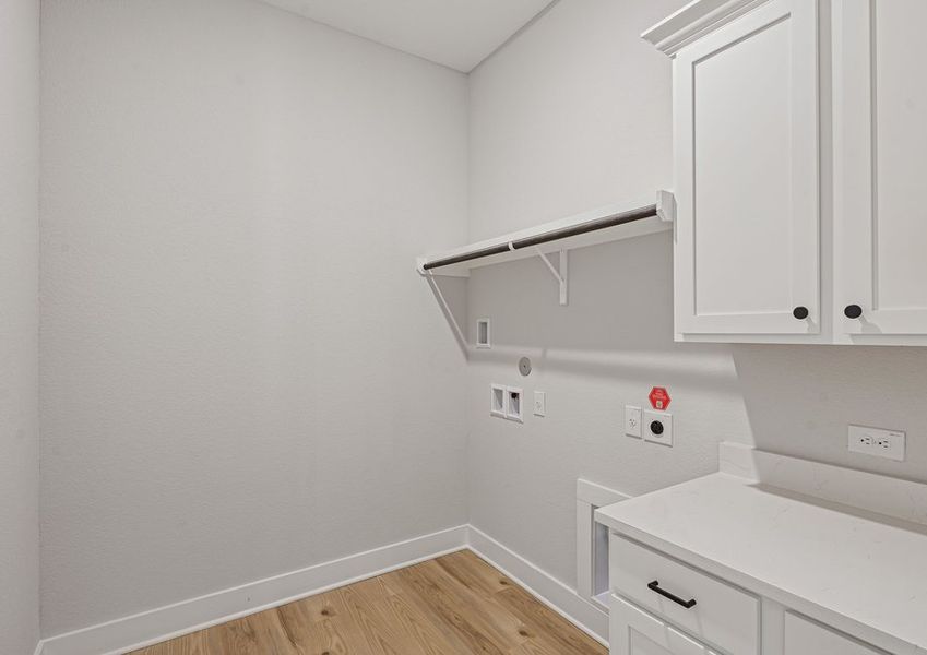 The laundry room has hanging space and cabinet space.
