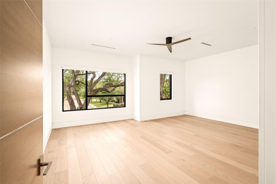 Airy secondary bedroom featuring dual-aspect windows and a peaceful residential view.