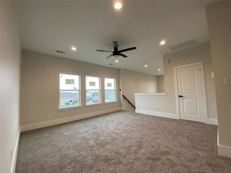 Empty room with ceiling fan and carpet floors