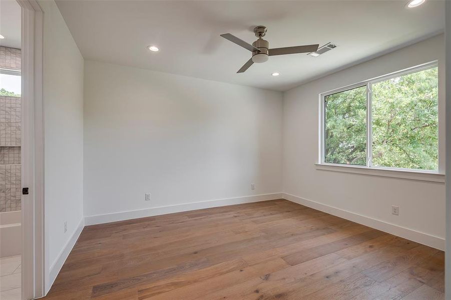 Bedroom with a wealth of natural light, hardwood / wood-style floors, and ceiling fan