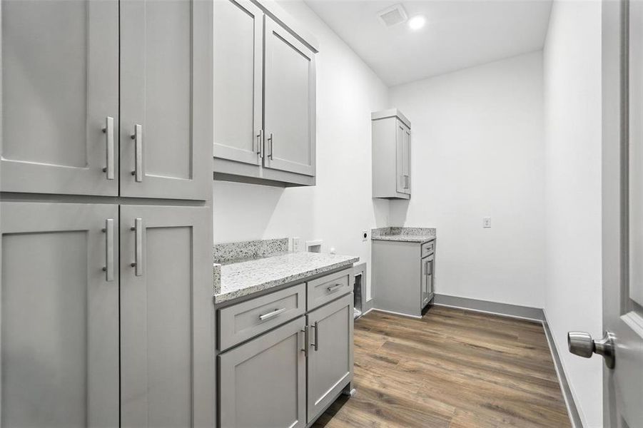 Laundry area with dark wood finished floors, cabinet space, electric dryer hookup, recessed lighting, and washer hookup Laundry area with dark wood finished floors, cabinet space, electric dryer hookup, recessed lighting, and washer hookup