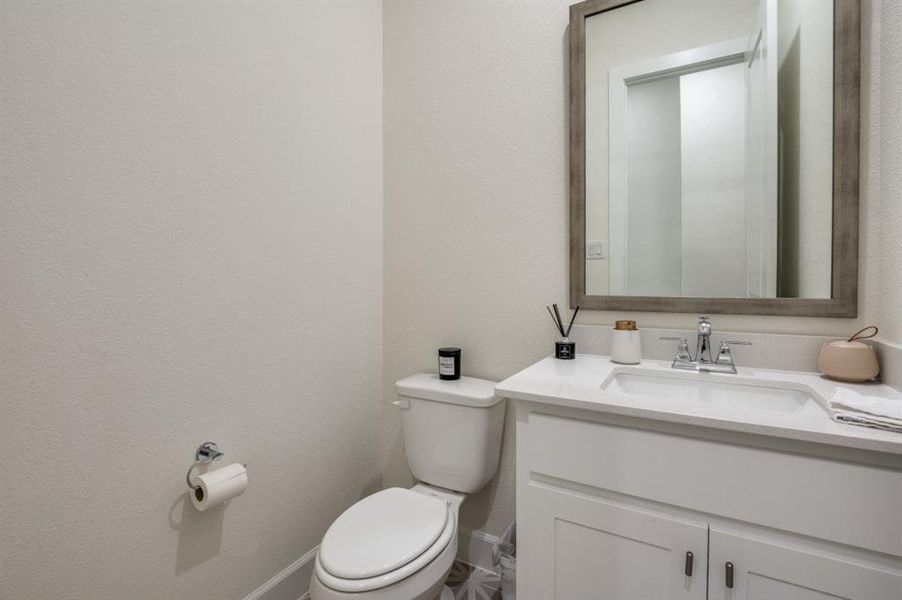 Bathroom featuring vanity and a textured wall Bathroom featuring vanity and a textured wall