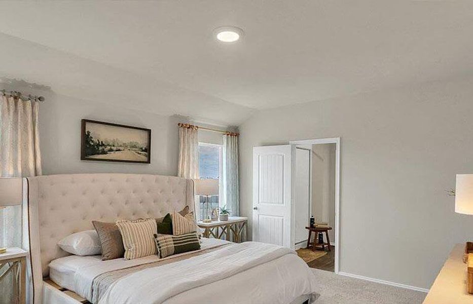 Carpeted bedroom with vaulted ceiling and baseboards Carpeted bedroom with vaulted ceiling and baseboards