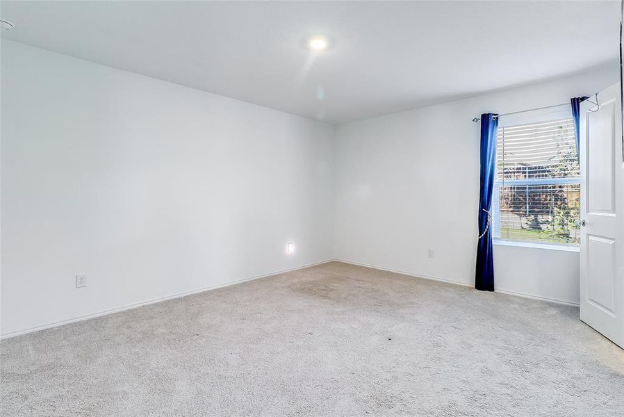 Empty room featuring light colored carpet and baseboards