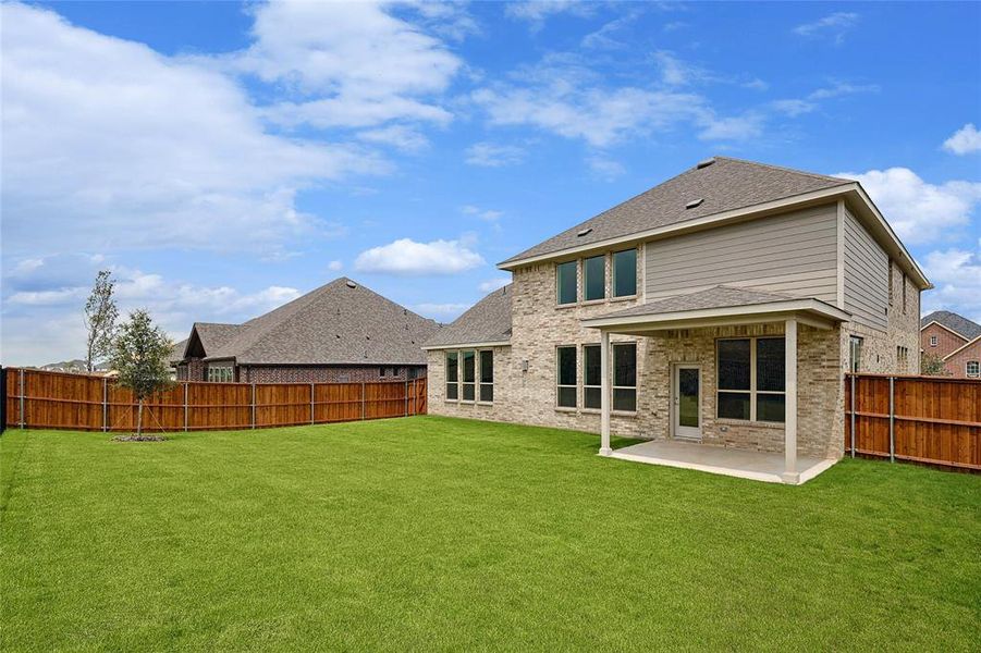 Rear view of property featuring a patio and a lawn