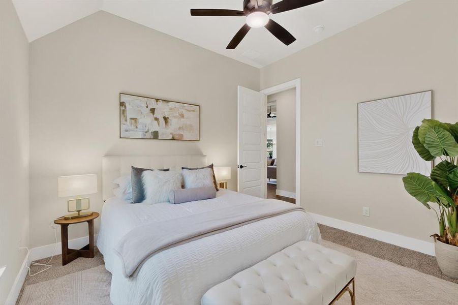 Carpeted bedroom featuring vaulted ceilings, a ceiling fan, and white five-panel doors