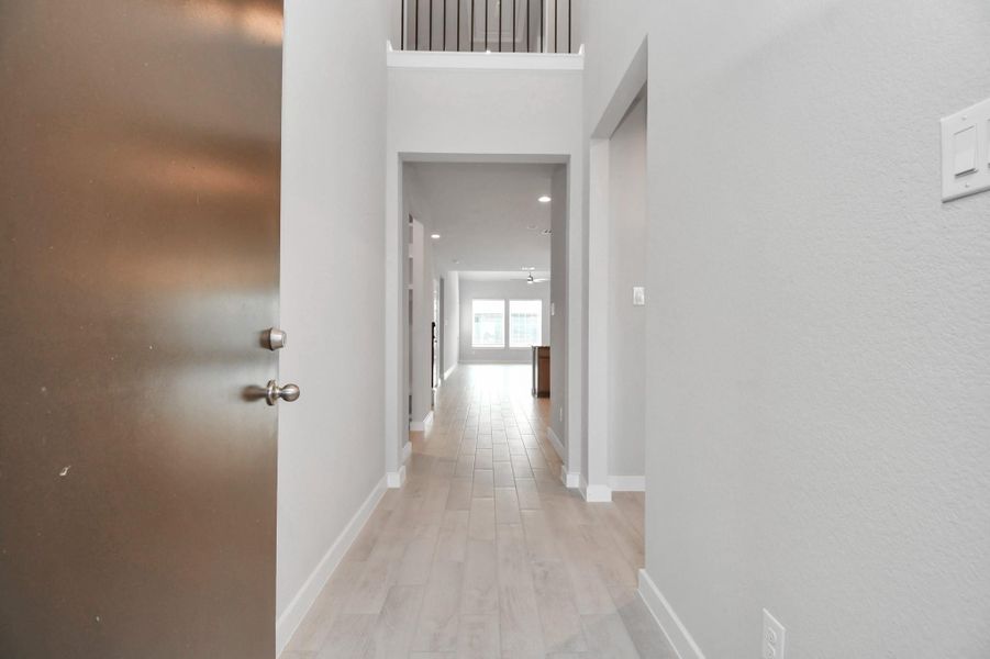 As you step into the threshold of this luxurious home, you'll soon be welcomed by an elegant glass door (to be installed). Inside, soaring ceilings amplify the spaciousness, while the refined wood-look tile flooring and oversized baseboards exude sophistication and charm. Sample photo of completed home with similar floor plan. Actual colors and selections may vary.