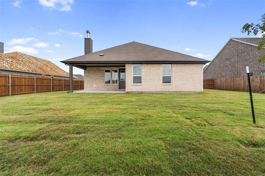 Back of house featuring brick siding, a chimney, a patio area, a fenced backyard, and a shingled roof Back of house featuring brick siding, a chimney, a patio area, a fenced backyard, and a shingled roof