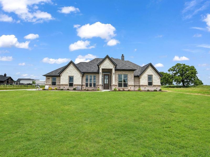 French country home featuring a chimney, stone siding, roof with shingles, and brick siding