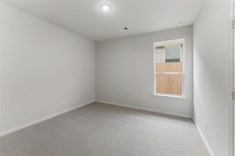 Neutral tone wall finishes, recessed ceiling lighting, light gray carpeting, and white baseboards