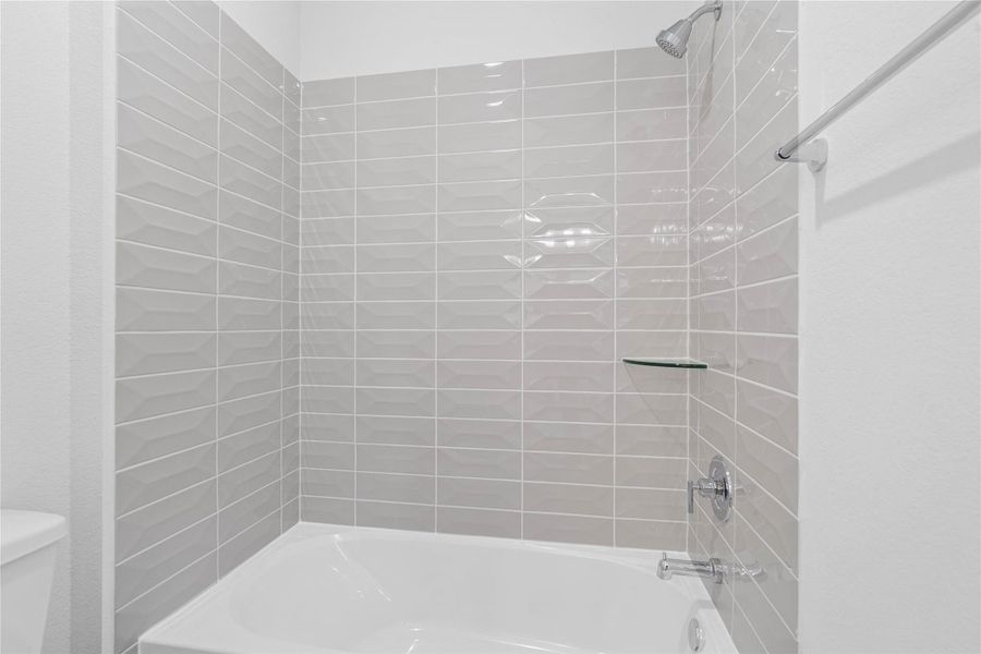 This additional view of the secondary bath highlights the tub/shower combination with tile surround.