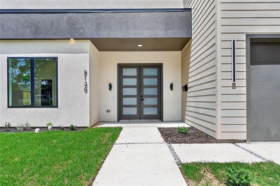 Contemporary architectural facade featuring a double entry door with frosted glass panels, smooth stucco finishes, and horizontal siding Contemporary architectural facade featuring a double entry door with frosted glass panels, smooth stucco finishes, and horizontal siding