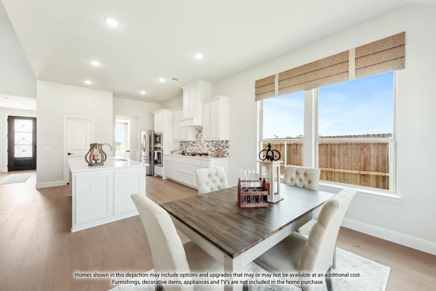 Open dining area with wood table and upholstered chairs next to kitchen with white cabinets and hardwood floors Open dining area with wood table and upholstered chairs next to kitchen with white cabinets and hardwood floors