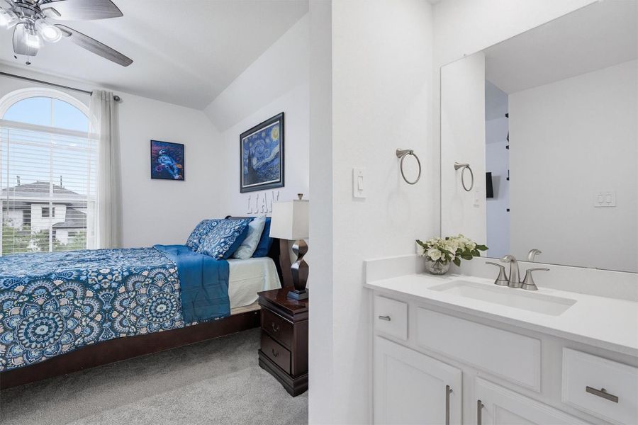 This bedroom suite offers a private sink vanity, with access to a shared shower/tub combo and toilet, offering privacy and convenience.