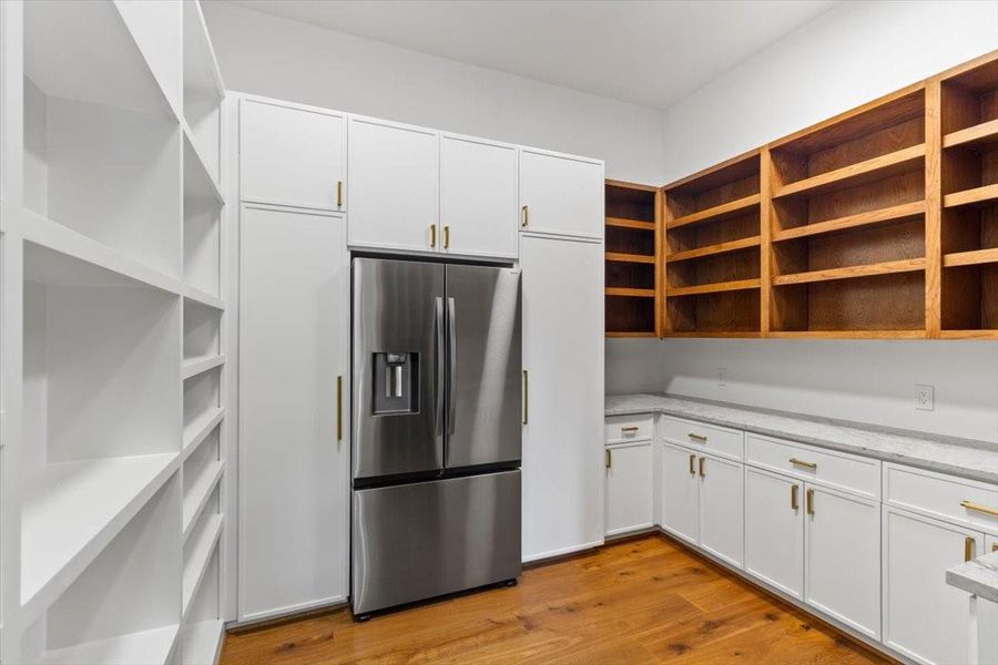The working pantry provides ample storage and features open oak shelves, a full size counter-depth refrigerator