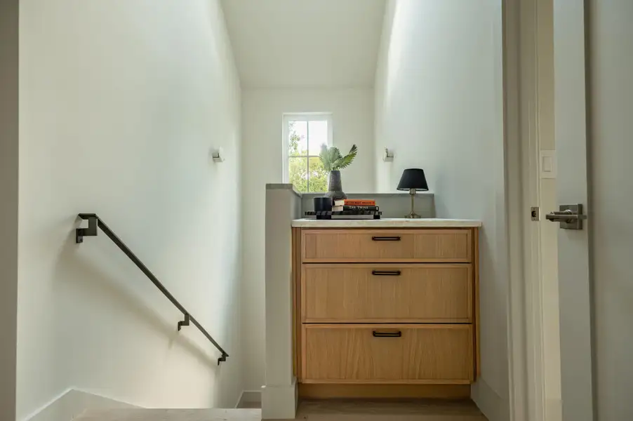 Natural light pours over a built-in landing vanity on hardwood flooring near the staircase. Natural light pours over a built-in landing vanity on hardwood flooring near the staircase.