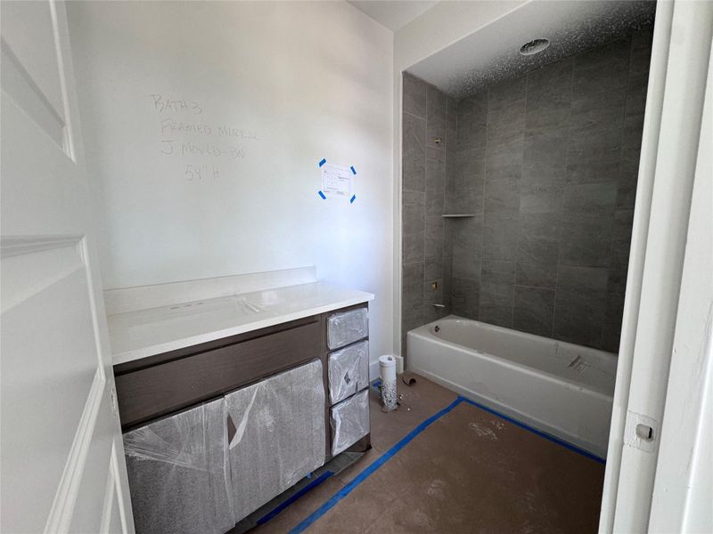 A fresh bathroom design showcases a modern vanity and a tiled bath enclosure. A fresh bathroom design showcases a modern vanity and a tiled bath enclosure.