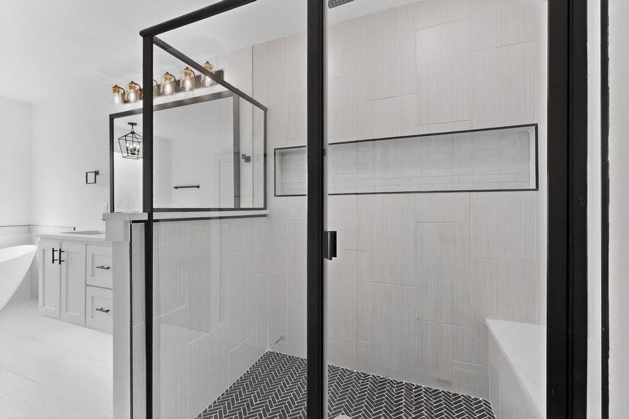 Full bathroom featuring a soaking tub, a stall shower, and vanity