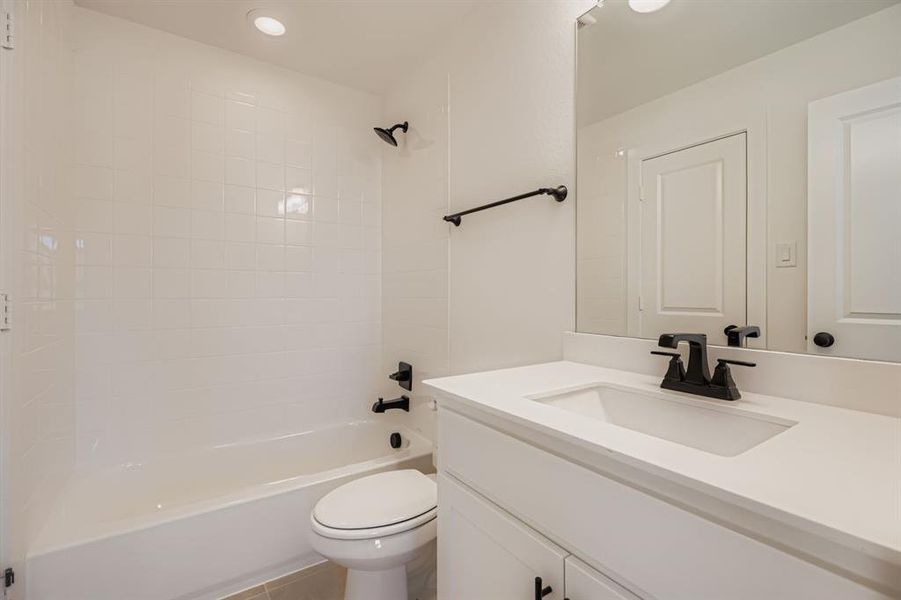 Bathroom featuring vanity, shower / bathtub combination, and light tile patterned floors Bathroom featuring vanity, shower / bathtub combination, and light tile patterned floors