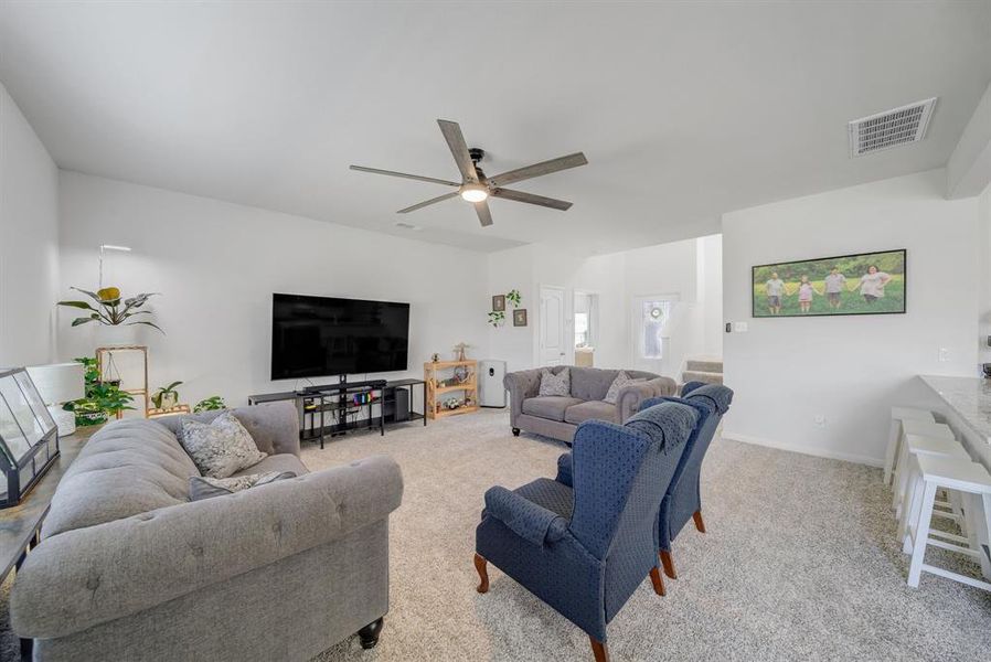 Living room with carpet flooring and a ceiling fan