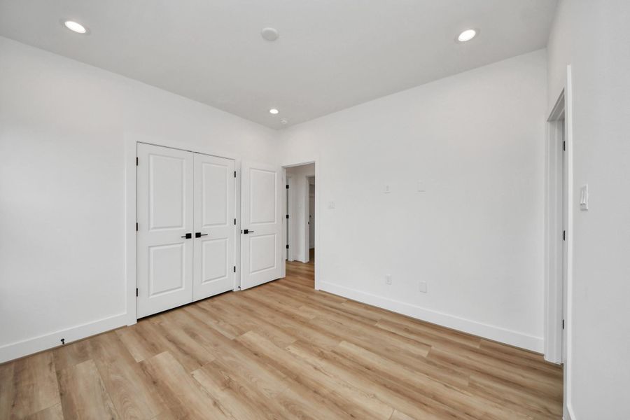 This inviting third bedroom on the second floor features sleek wood floors, abundant natural light, and ample closet space, perfect for creating a cozy retreat.