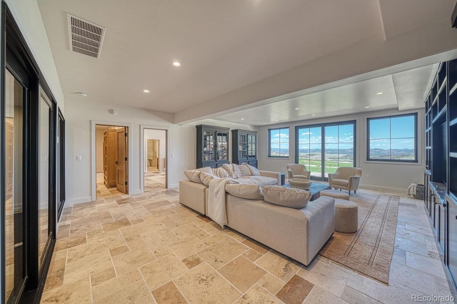 A spacious lounge with built-in cabinetry, media storage and travertine tile connects seamlessly to the patio for indoor-outdoor flow. A spacious lounge with built-in cabinetry, media storage and travertine tile connects seamlessly to the patio for indoor-outdoor flow.