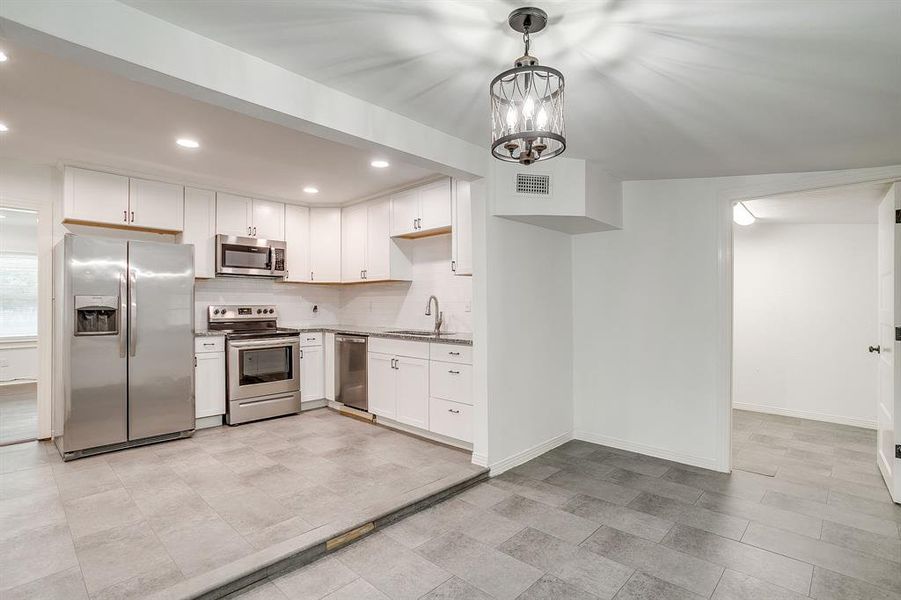 Kitchen featuring stainless steel appliances, recessed lighting, and backsplash