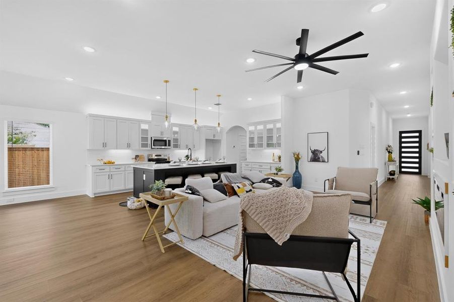 Open-concept living area featuring wood-finish flooring, recessed lighting, and a modern ceiling fan