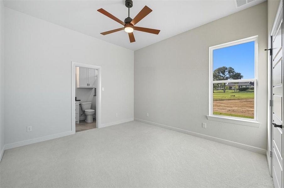 Unfurnished bedroom with light carpet, a ceiling fan, and ensuite bath Unfurnished bedroom with light carpet, a ceiling fan, and ensuite bath