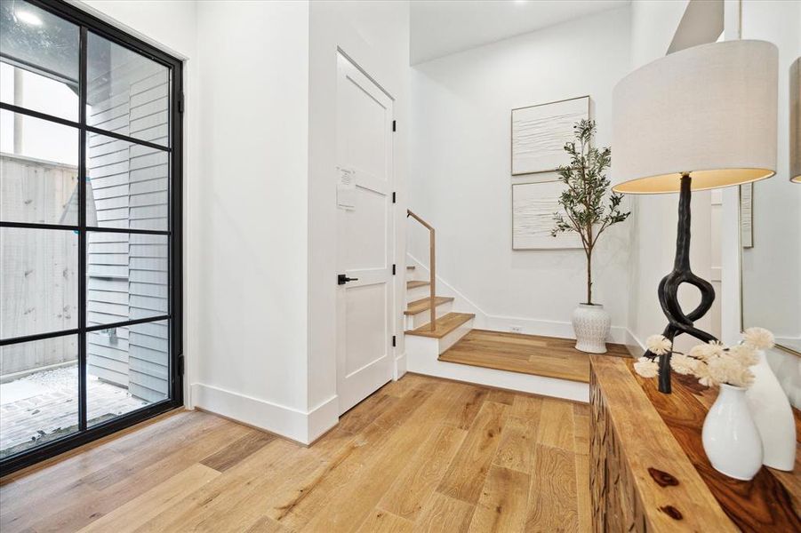 From the foyer, soaring 12-foot-tall ceilings with custom beams and oversized Lincoln aluminum windows come into view. To the left, the current coat closet or elevator-capable closet stands ready to offer future convenience and accessibility.