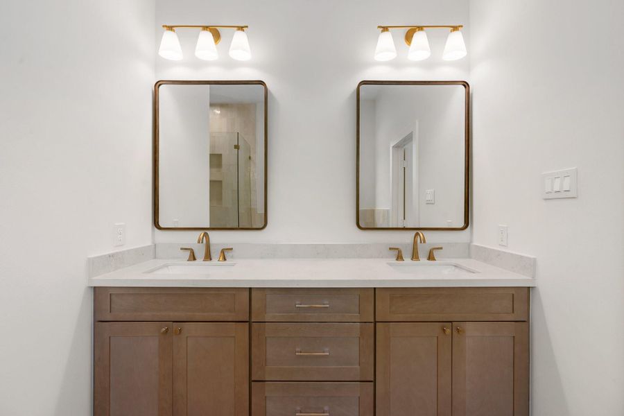 Stunning warm wood cabinetry pairs beautifully with quartz countertops, stylish hardware, and elegant light fixtures—bringing a refined, high-end feel to this spa-inspired vanity. Stunning warm wood cabinetry pairs beautifully with quartz countertops, stylish hardware, and elegant light fixtures—bringing a refined, high-end feel to this spa-inspired vanity.