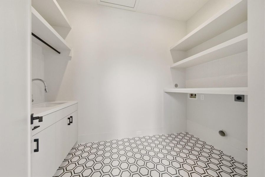 Large laundry room with storage and sink, conveniently located near all the bedrooms.