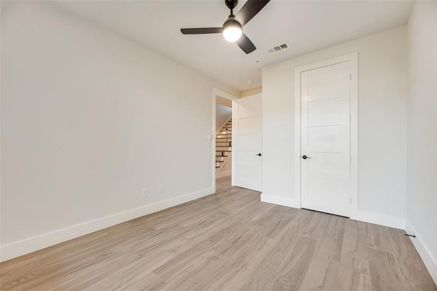 Unfurnished bedroom featuring light wood-style floors and a ceiling fan Unfurnished bedroom featuring light wood-style floors and a ceiling fan