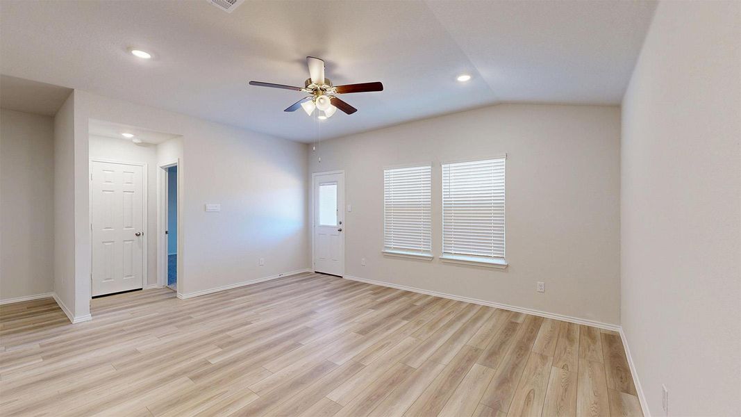 Laminate flooring graces this generous living area, complemented by overhead recessed lighting and a classic ceiling fan.