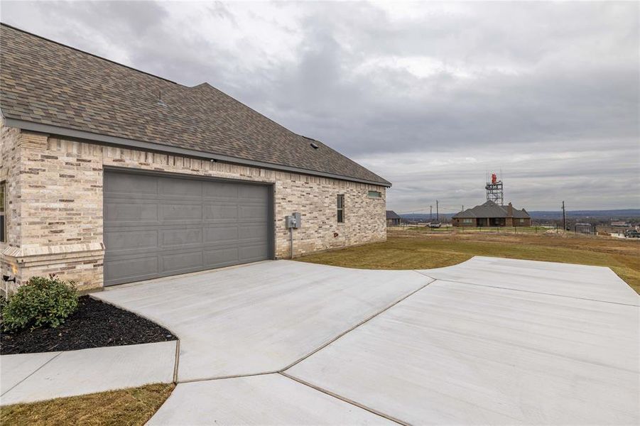 View of side of home with a yard and a garage