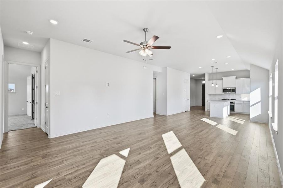 Unfurnished living room with recessed lighting, light wood-type flooring, ceiling fan, and lofted ceiling Unfurnished living room with recessed lighting, light wood-type flooring, ceiling fan, and lofted ceiling