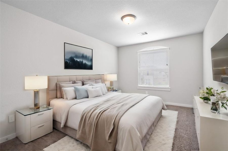 Secondary bedroom features plush carpet, neutral paint, lighting and a large window with privacy blinds.