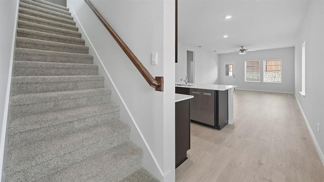 Staircase with recessed lighting, wood finished floors, and ceiling fan