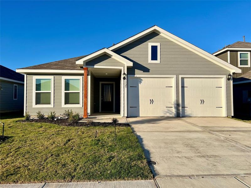 View of front facade featuring a front lawn and a garage