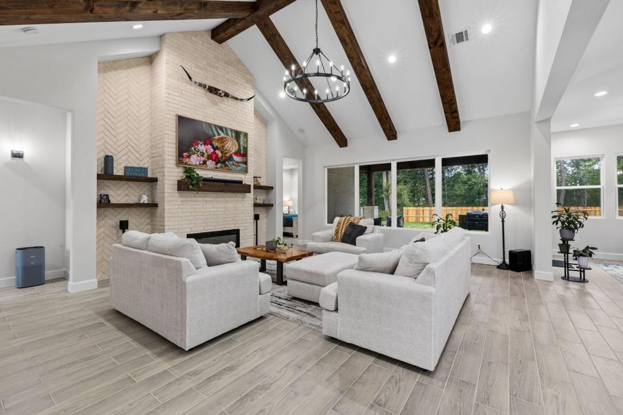 LIVING ROOM - Main living area with custom stained beams, a brick -surrounded fireplace and built ins.