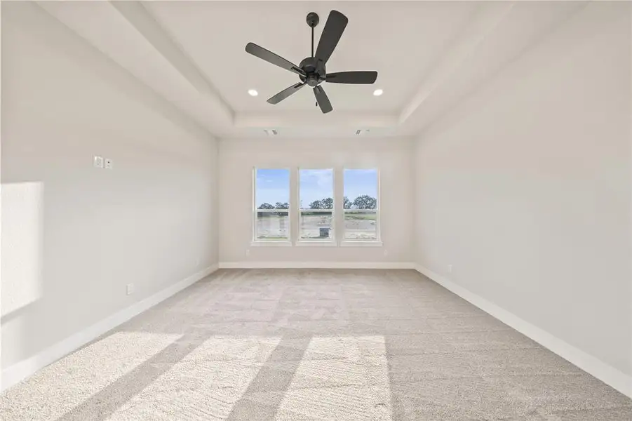 Spare room featuring light colored carpet, recessed lighting, a raised ceiling, baseboards, and a ceiling fan Spare room featuring light colored carpet, recessed lighting, a raised ceiling, baseboards, and a ceiling fan